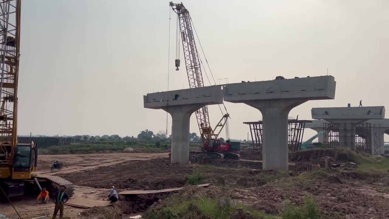 Hai cần cẩu bánh xích bên hàng trụ chữ T trên công trường cầu Ngọc Hồi