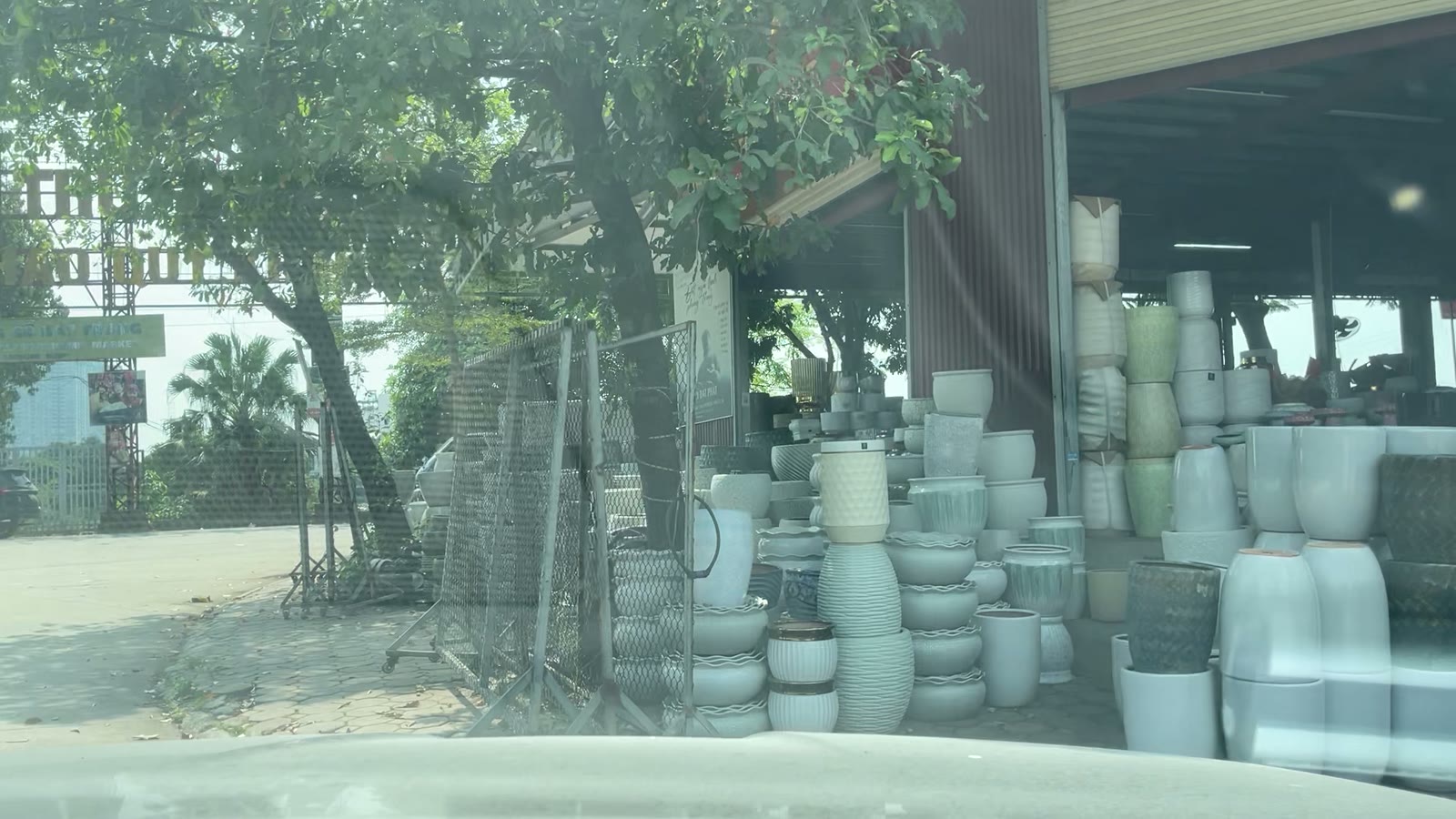 Chậu gốm trắng xếp chồng kín cửa hàng ven đường vào chợ gốm Bát Tràng