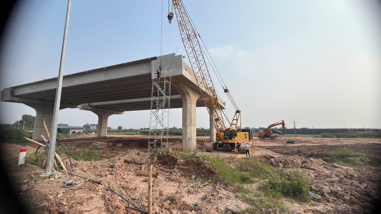 Đoạn cầu dẫn cầu Ngọc Hồi đã có dầm, cần cẩu và máy xúc vẫn làm việc phía sau