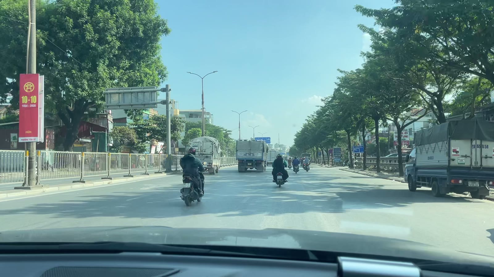 Quốc lộ 1A đoạn đã mở rộng nhiều làn, hai bên là hàng cây và nhà dân