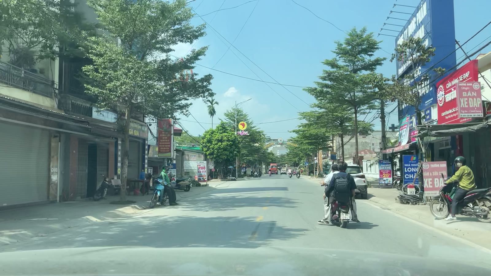 Đường tỉnh 379 qua Văn Giang buổi trưa, hai bên là nhà phố và hàng cây