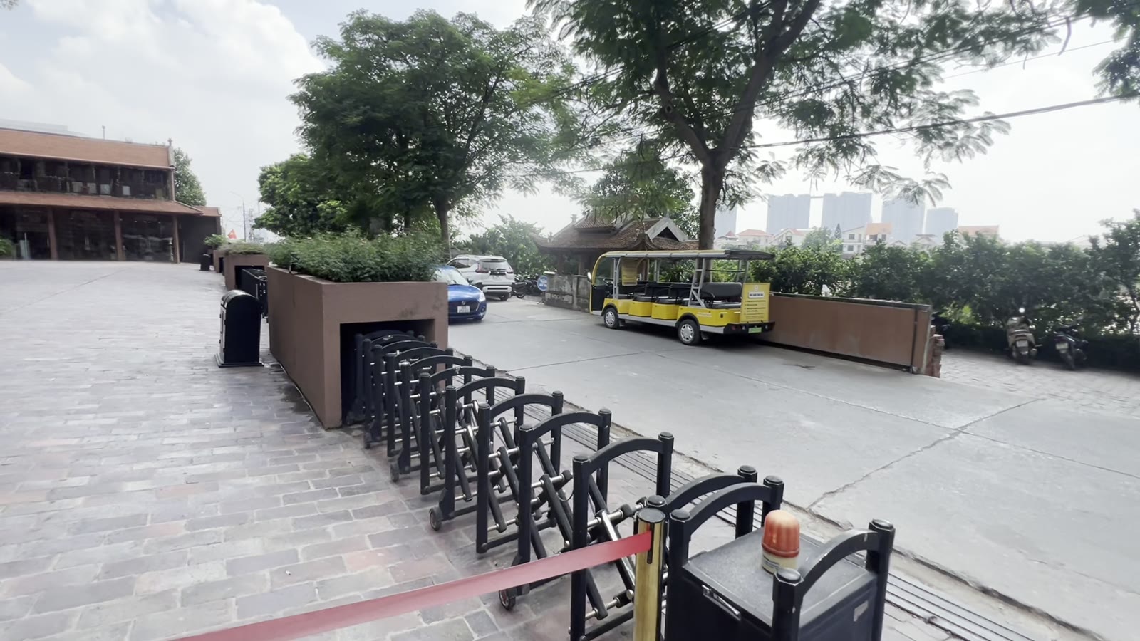 Xe điện chở khách tham quan đỗ ở sân lát gạch cạnh khu bảo tàng gốm Bát Tràng